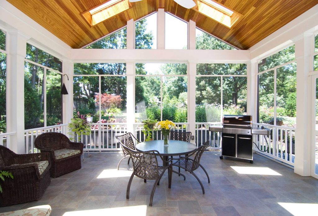 screened in back porch with vaulted wood ceiling skylights and stone floors